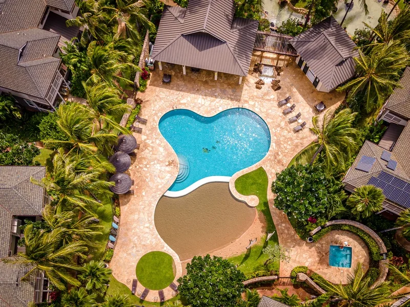 Vista aérea de una zona de piscina rodeada de vegetación tropical.