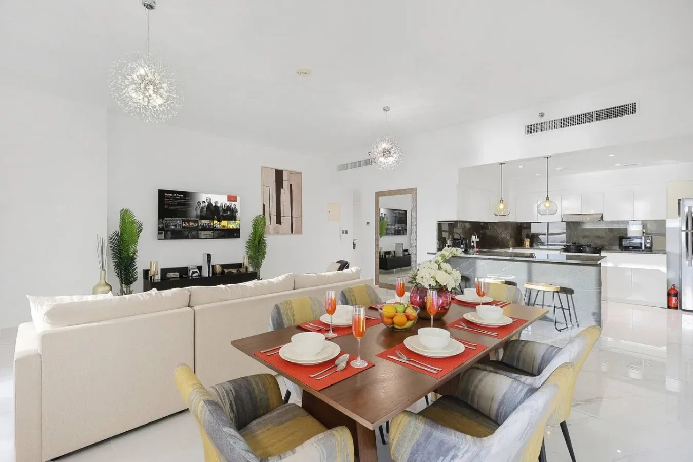 Una luminosa sala-comedor de concepto abierto con la cocina detrás de la mesa.