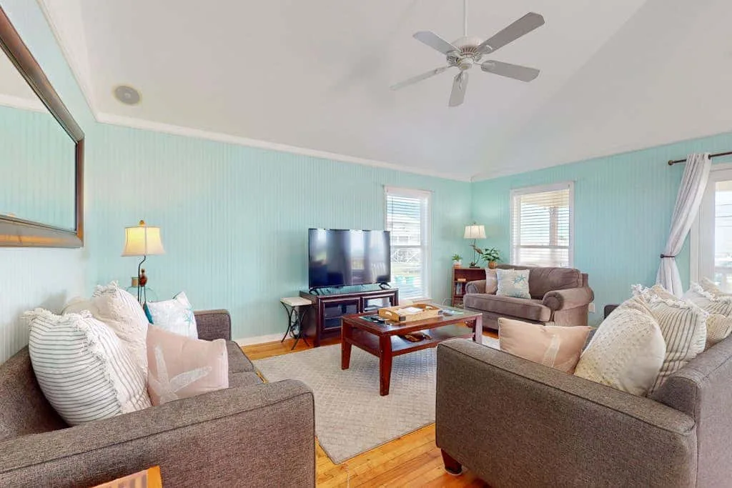 A living room with seating arranged around a television and coffee table.