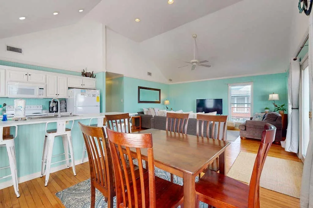 A dining area opens onto a living room, with a kitchen along the side.