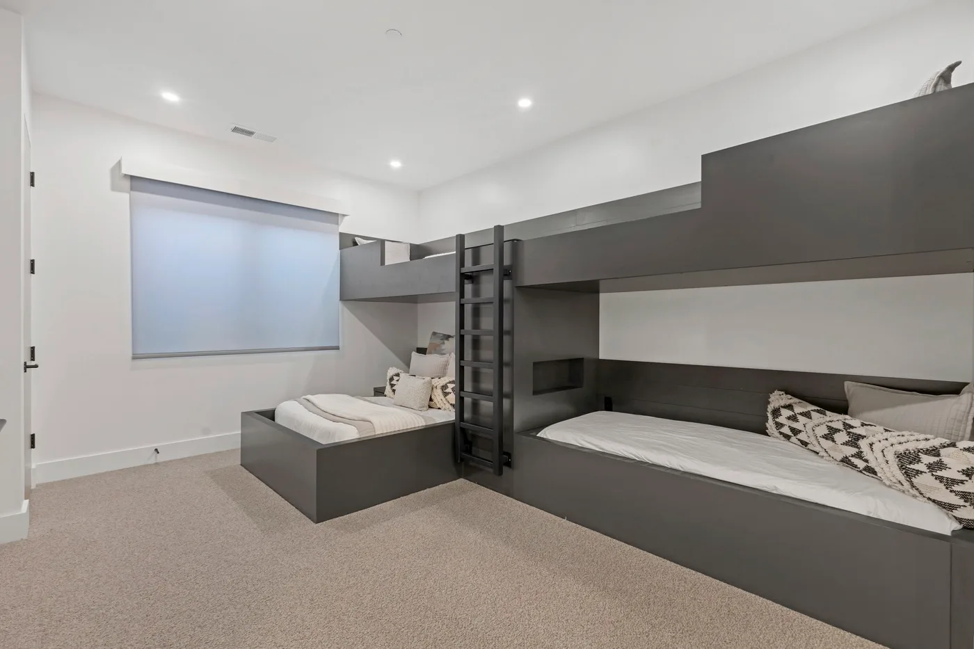 Un dormitorio con literas integradas y una ventana grande.