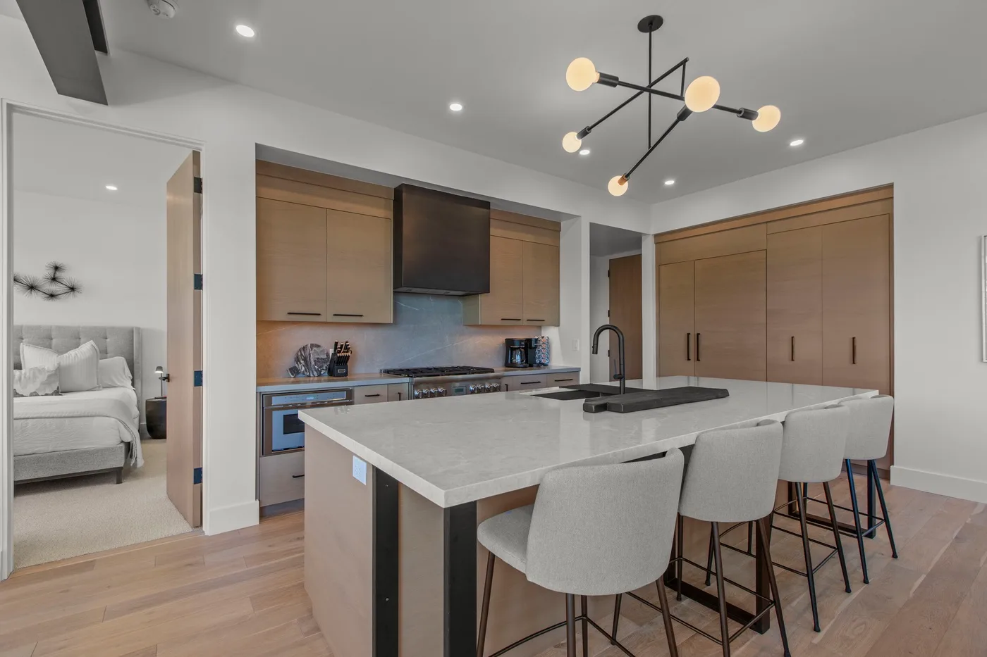 Una cocina moderna con una gran isla y asientos de color claro.