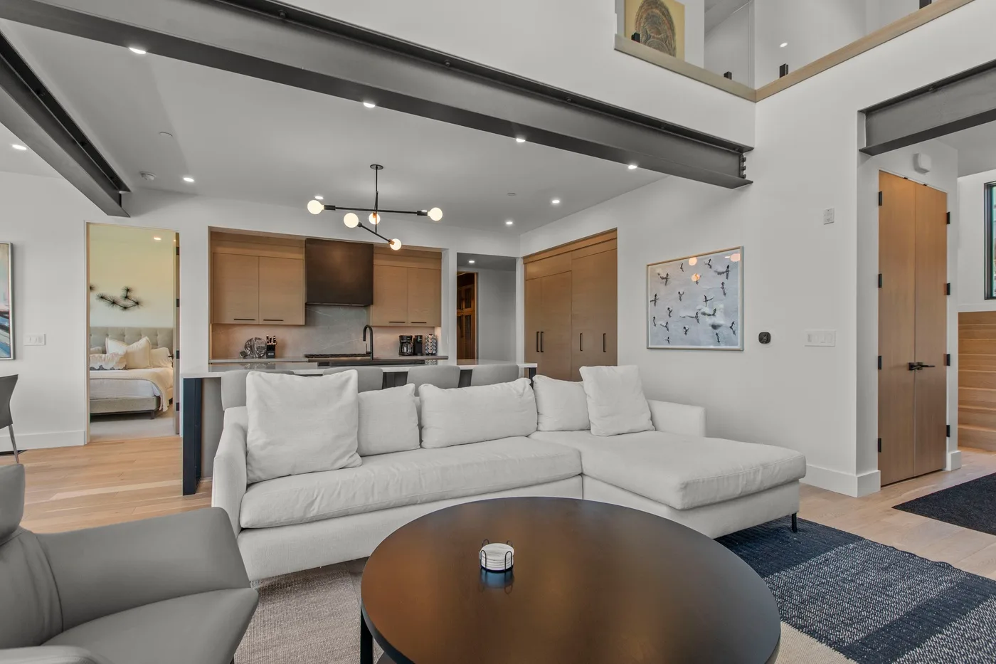 Una luminosa sala de estar de planta abierta con asientos, comedor y cocina.