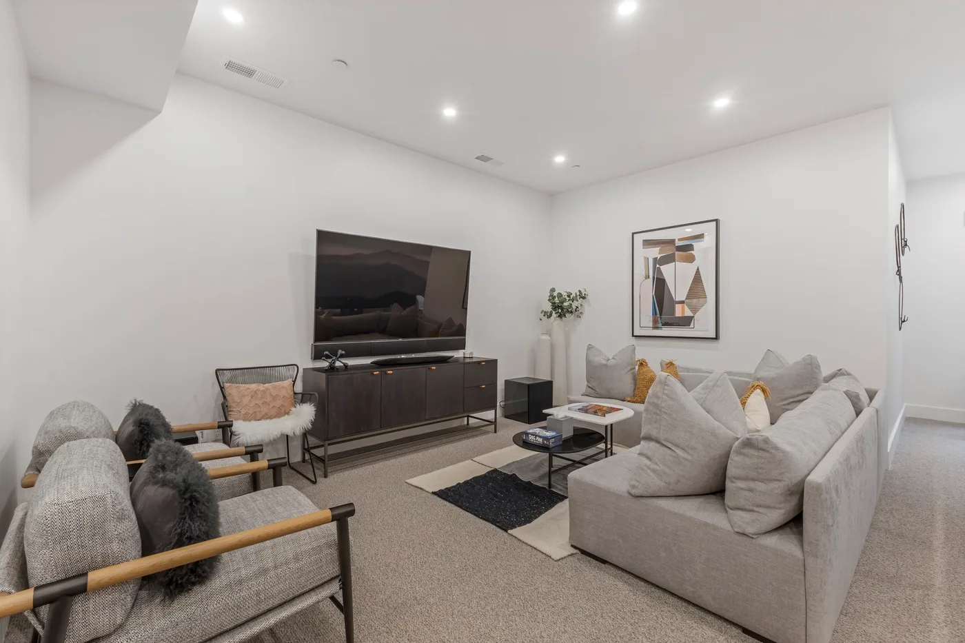 Una sala luminosa con asientos dispuestos alrededor de un televisor y una mesa de centro.