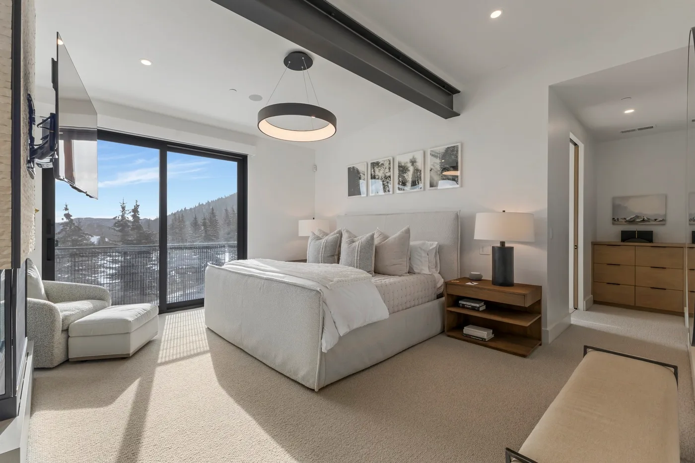 Un dormitorio luminoso con una cama grande junto a una ventana de piso a techo.