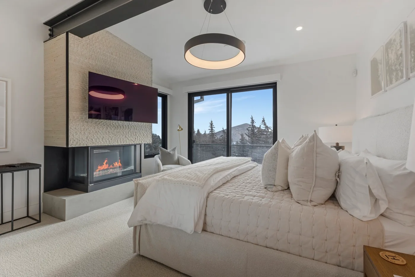 Un dormitorio luminoso con una cama grande y una chimenea junto a la ventana.