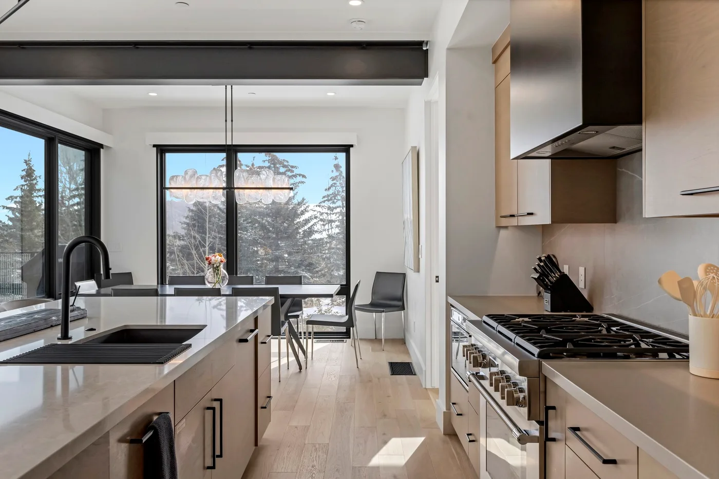 Una cocina moderna y luminosa con una isla central y ventanales.