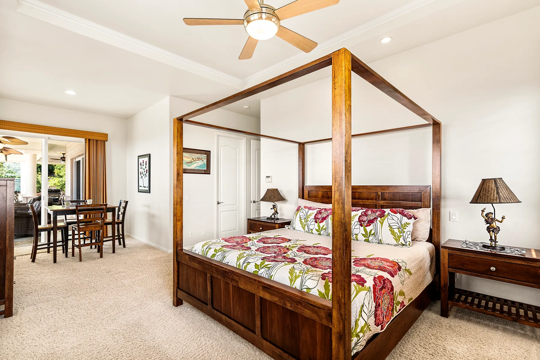 Un dormitorio con una cama de madera con dosel y un comedor visible al fondo.