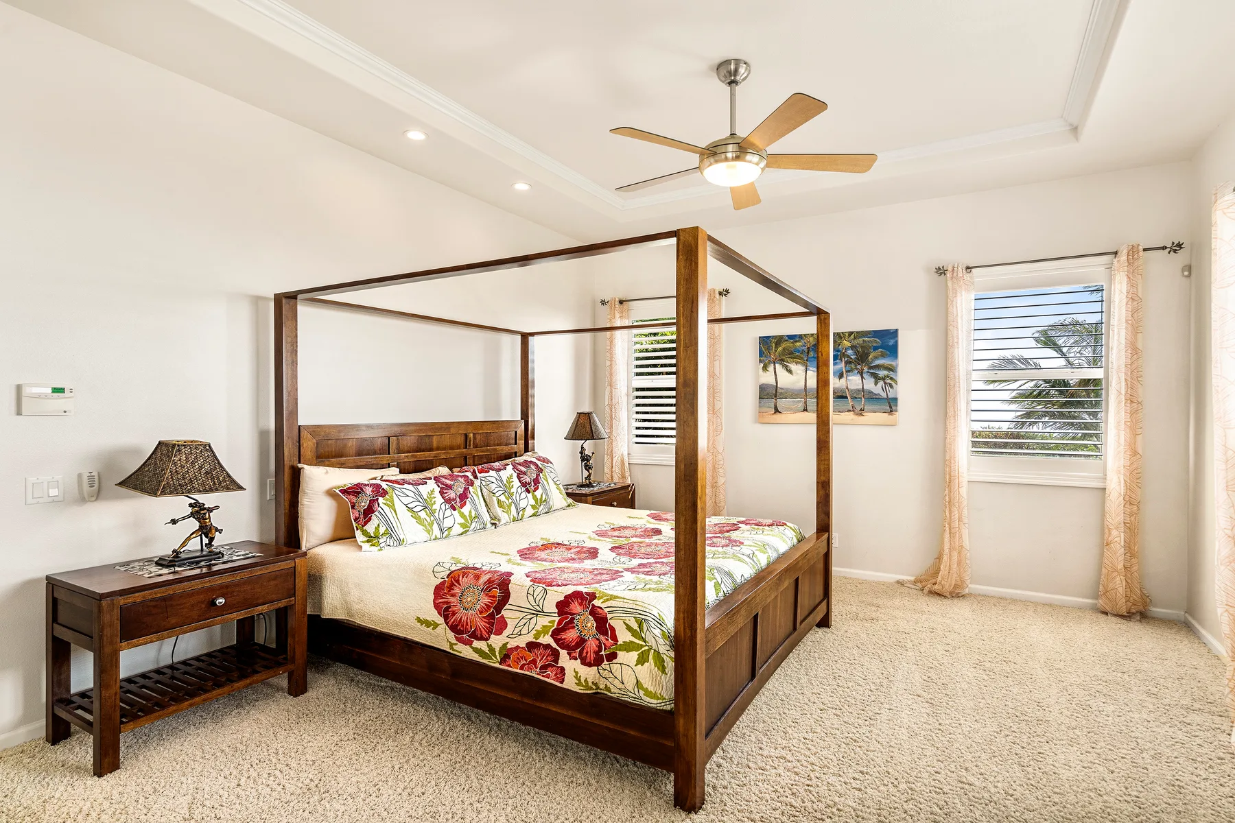 Un dormitorio luminoso con una cama con dosel de madera y ropa de cama floral.