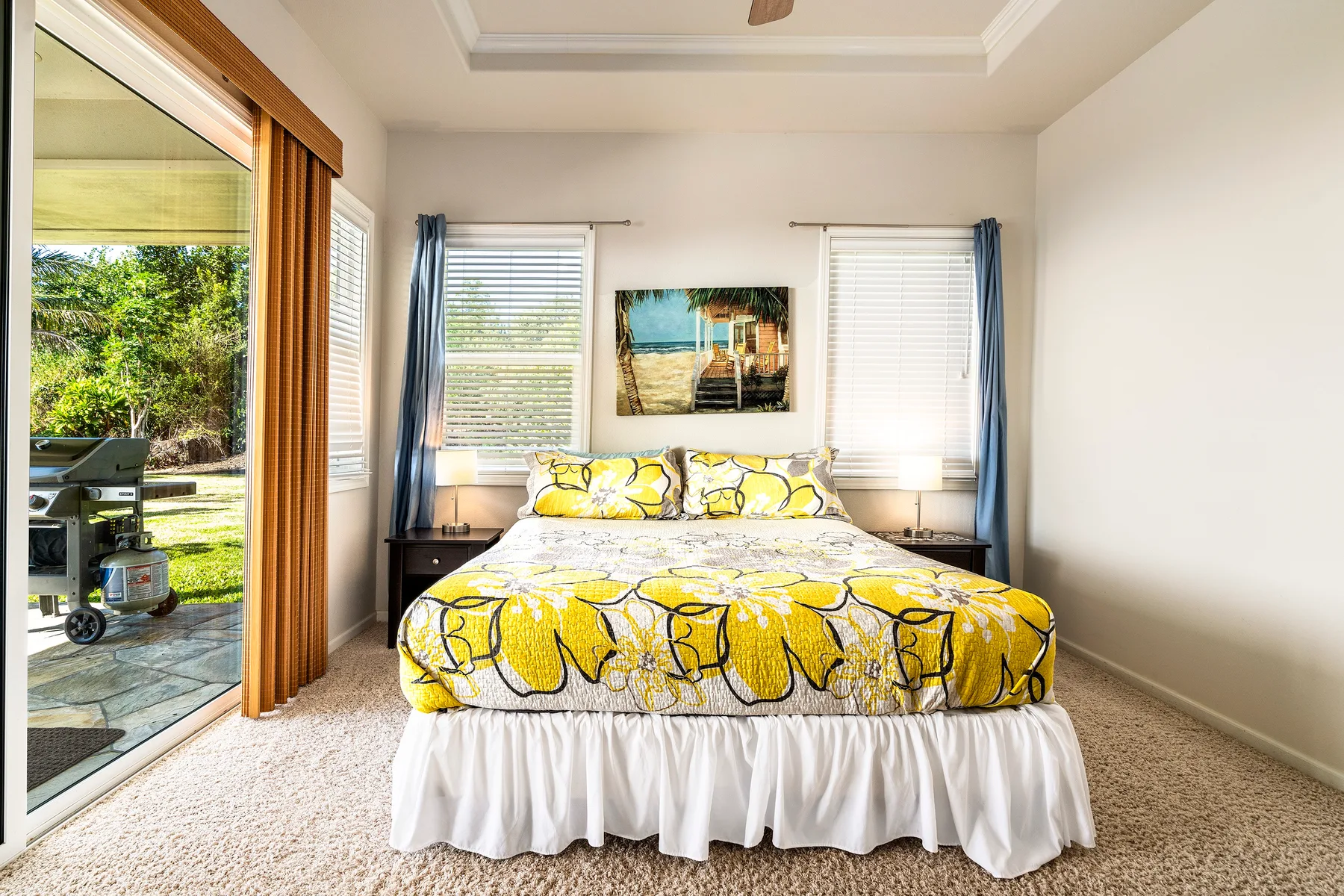 Un dormitorio con una cama cubierta con una colcha floral amarilla.