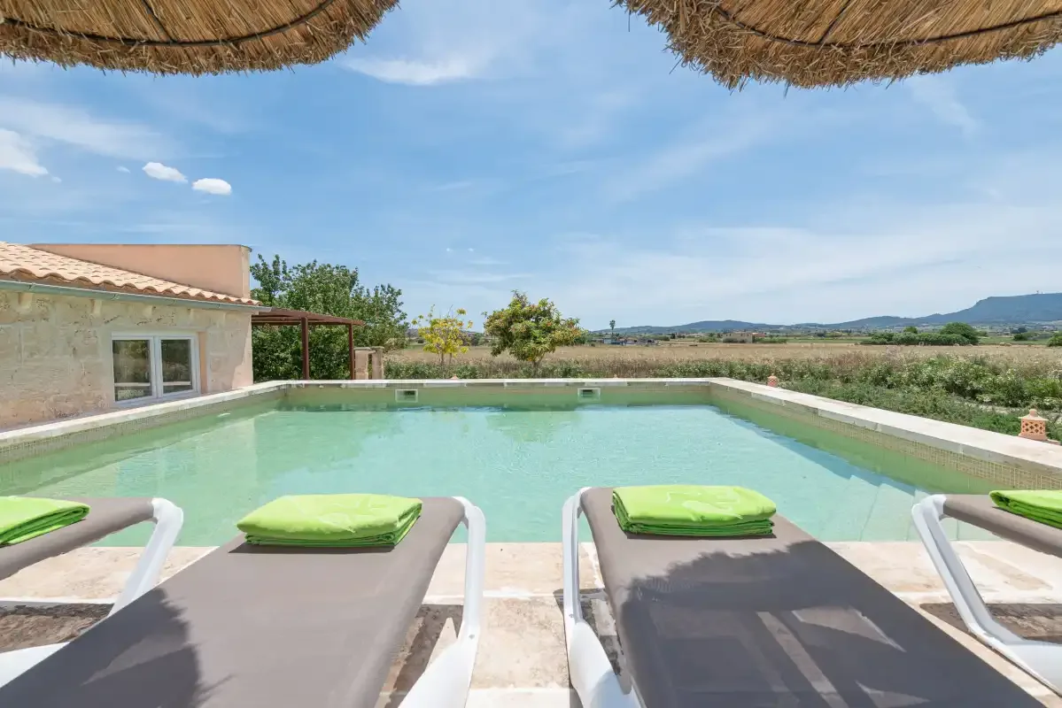 Una piscina al aire libre con tumbonas ofrece vistas al campo abierto.
