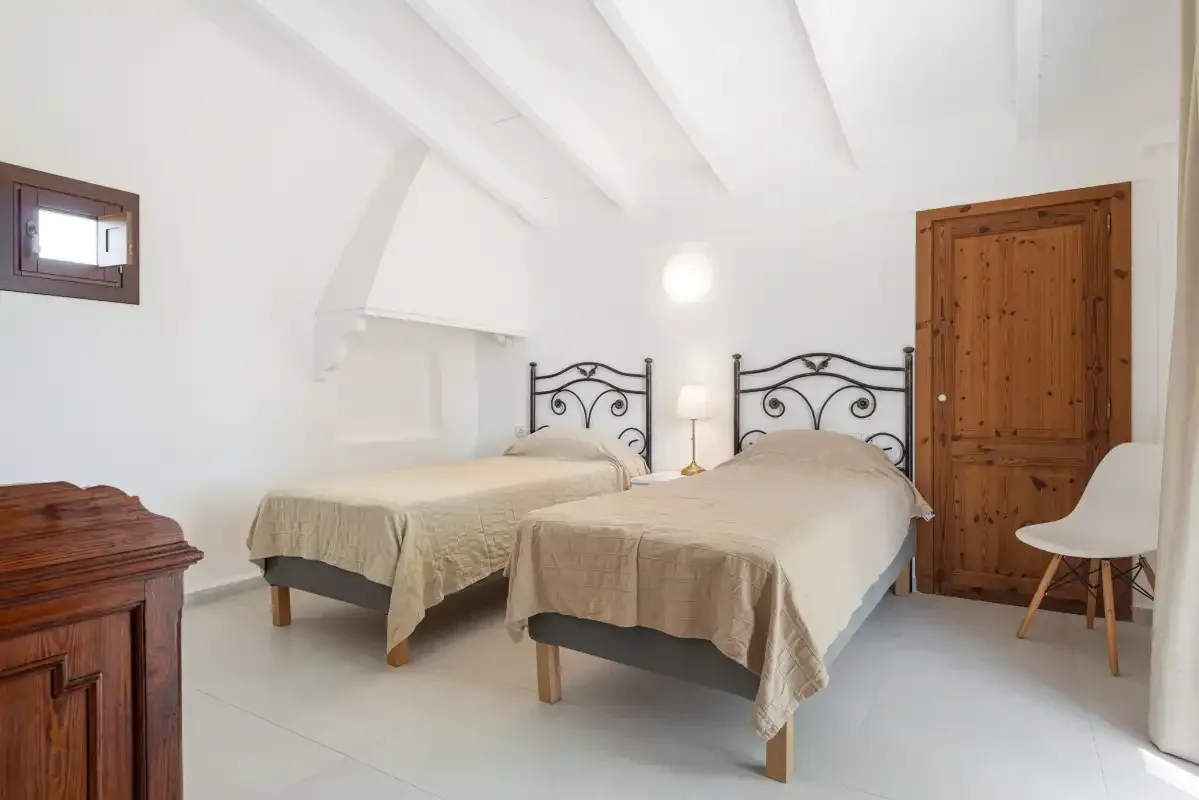 Un dormitorio luminoso con dos camas y una puerta de madera.