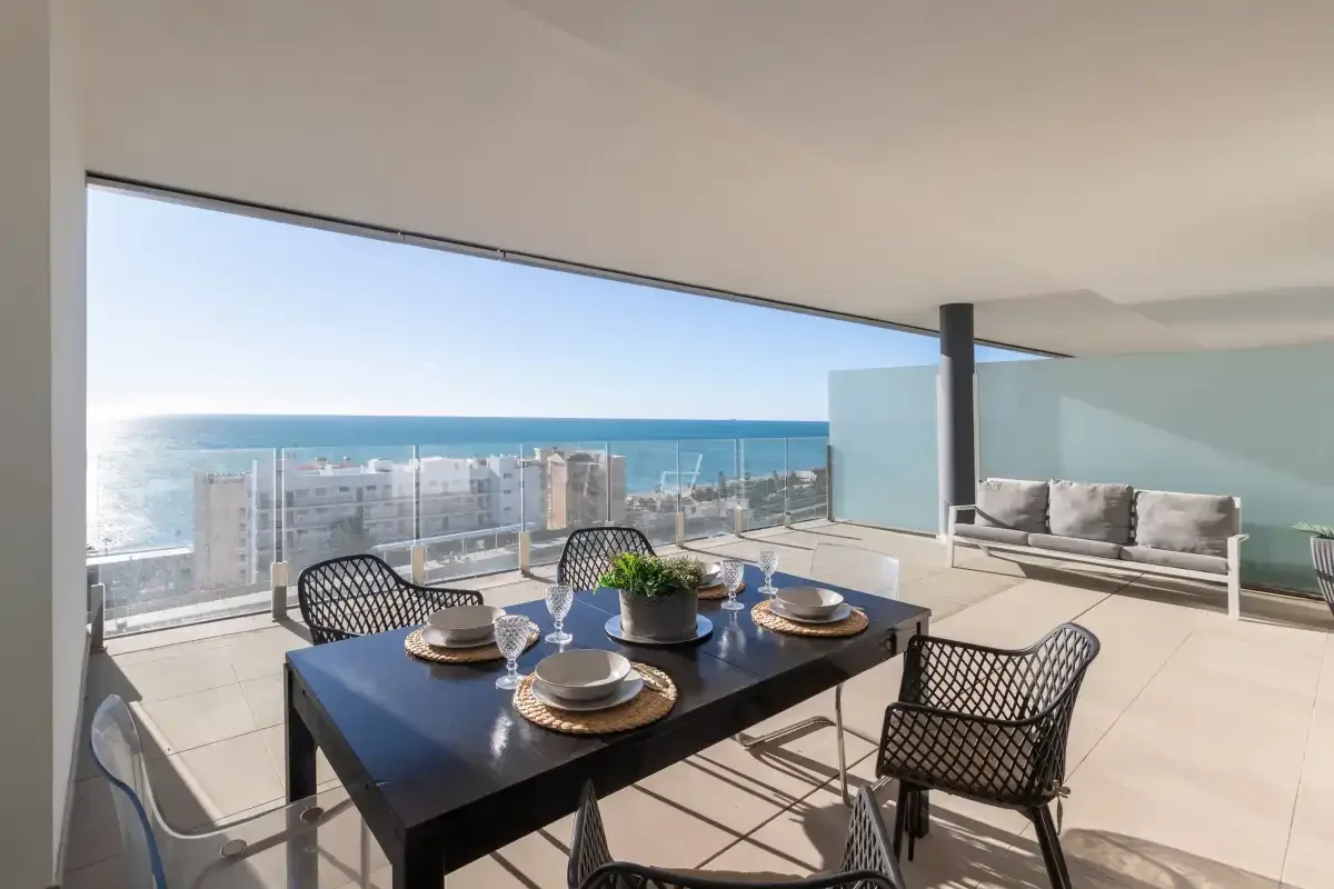 Una zona de comedor en la azotea da al mar, con una mesa y asientos en la terraza.