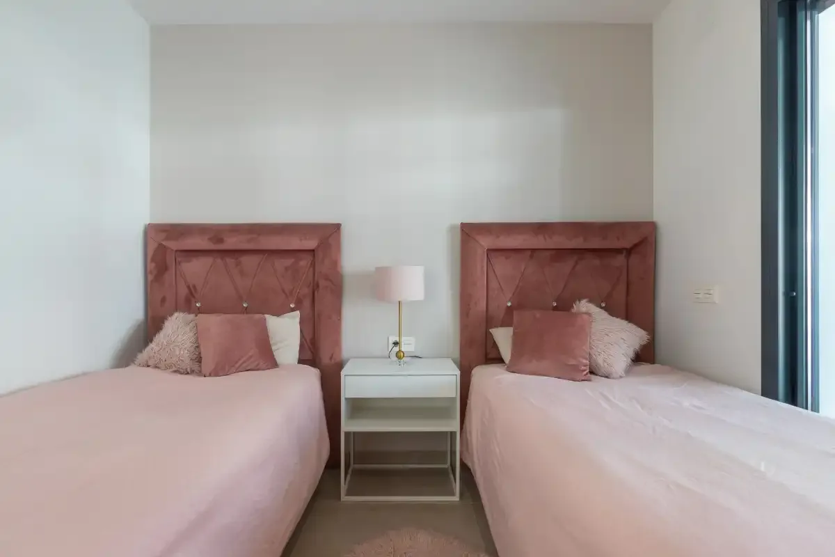 Un dormitorio con dos camas y una mesa pequeña entre ellas.