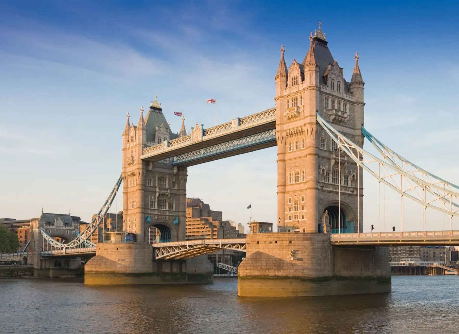 Tower Bridge spans the River Thames, with its two towers reflected in the water.