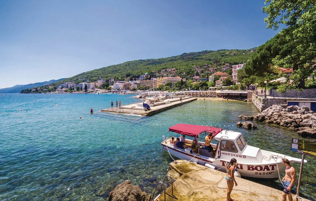 Coastal swimming area with a small boat beside a rocky shore.
