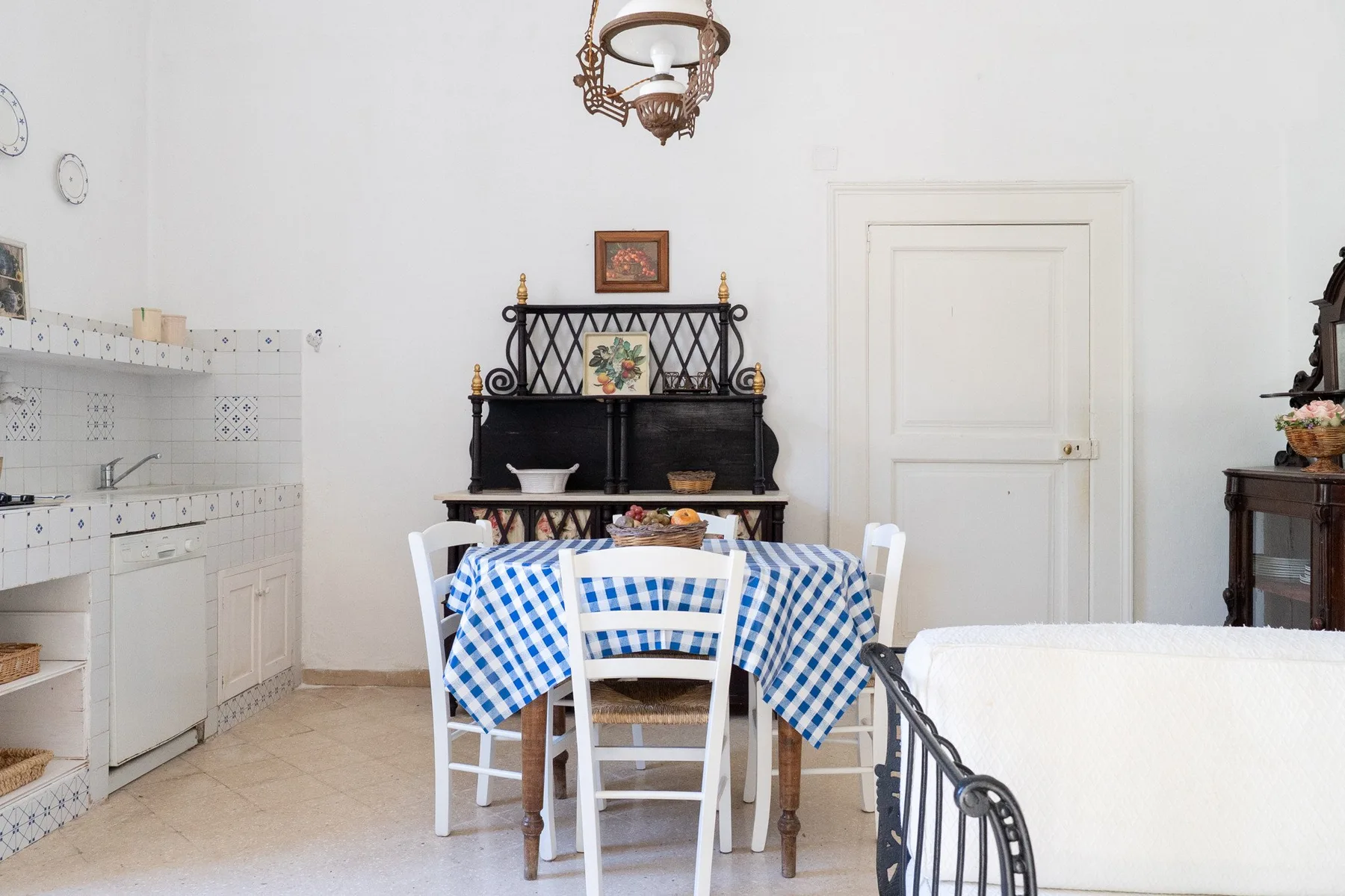 Un comedor con un mantel de cuadros azules y blancos y una encimera de cocina alicatada.
