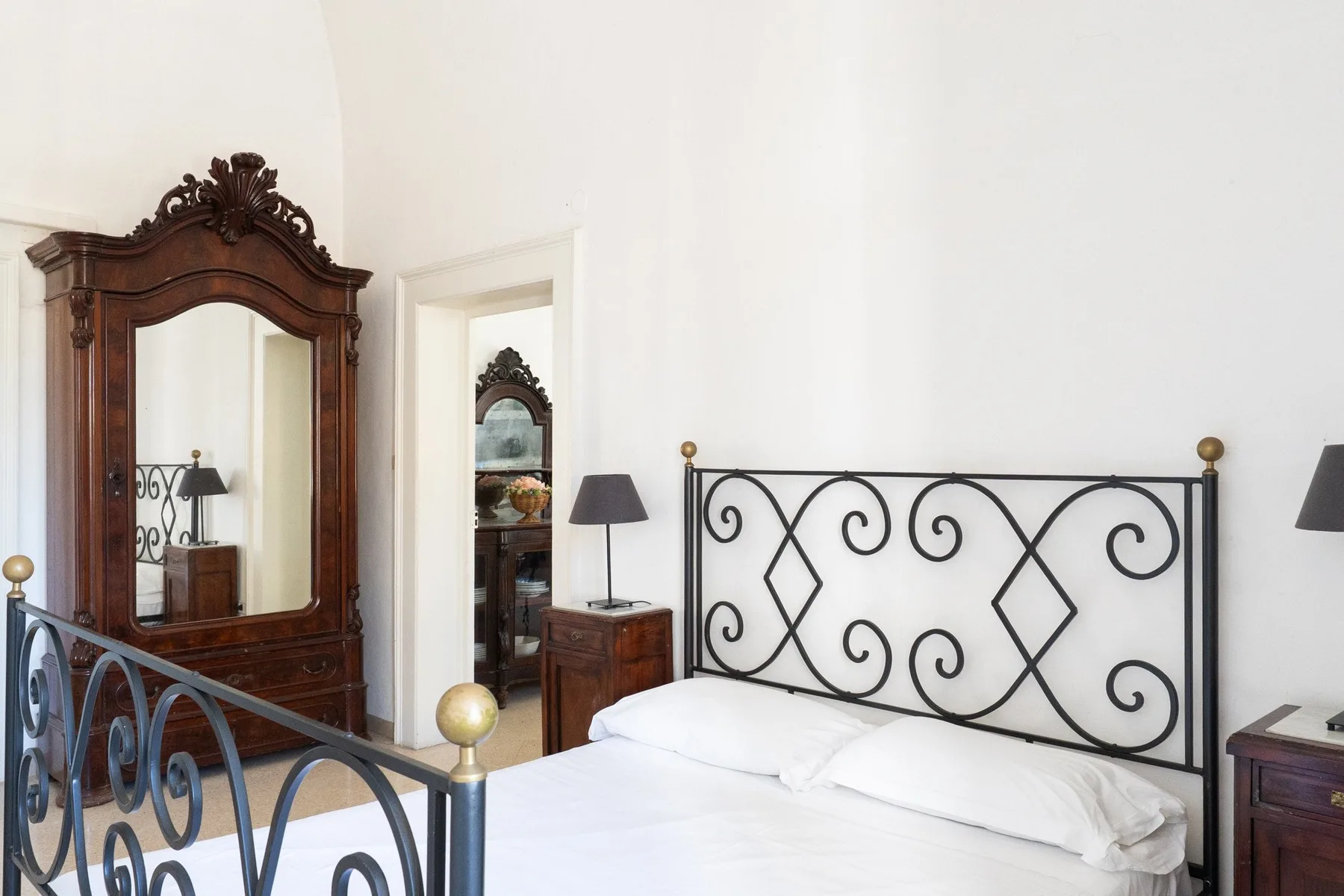 Un dormitorio con una cama y un cabecero decorativo de metal negro.
