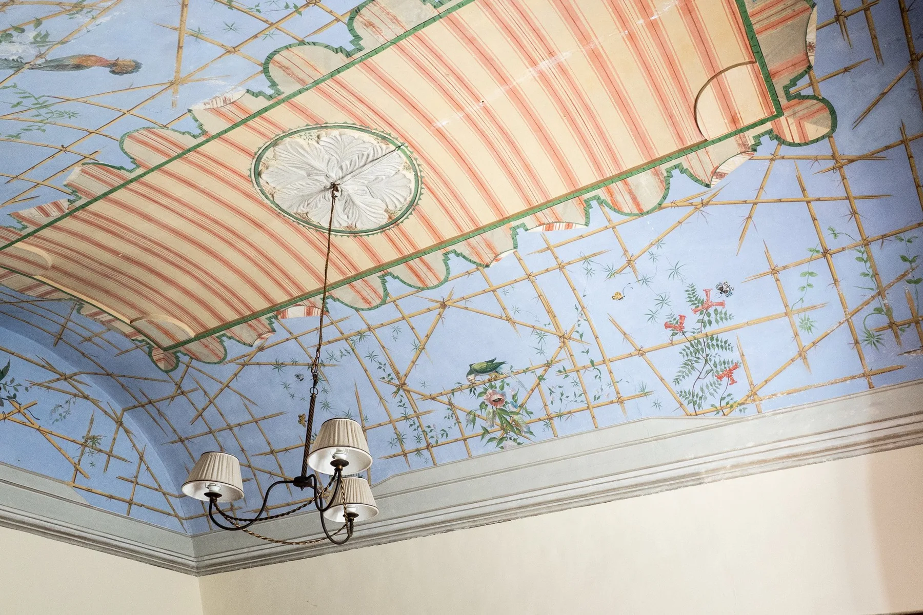 Un techo decorado presenta un toldo a rayas y una lámpara colgante.