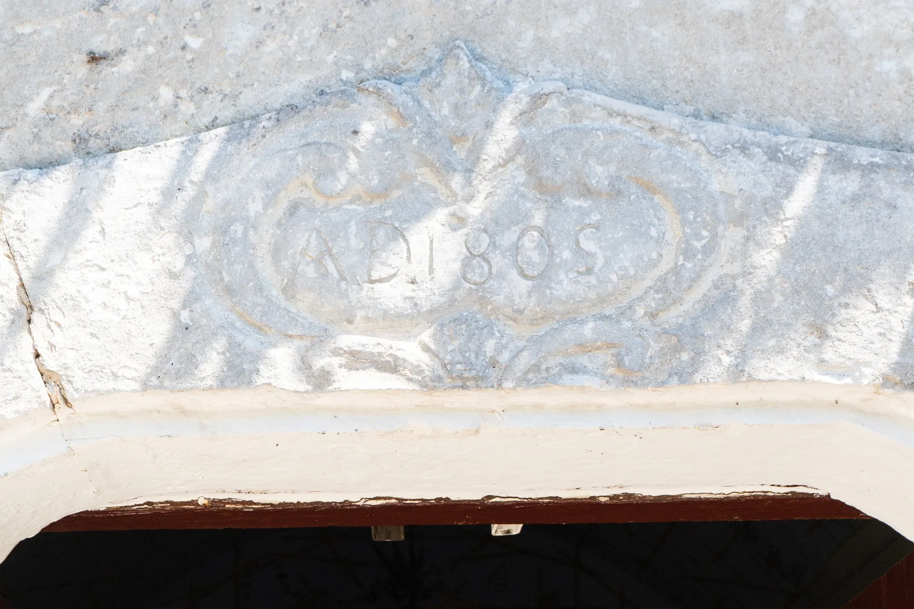 Un primer plano de una superficie de piedra desgastada con marcas talladas tenues.