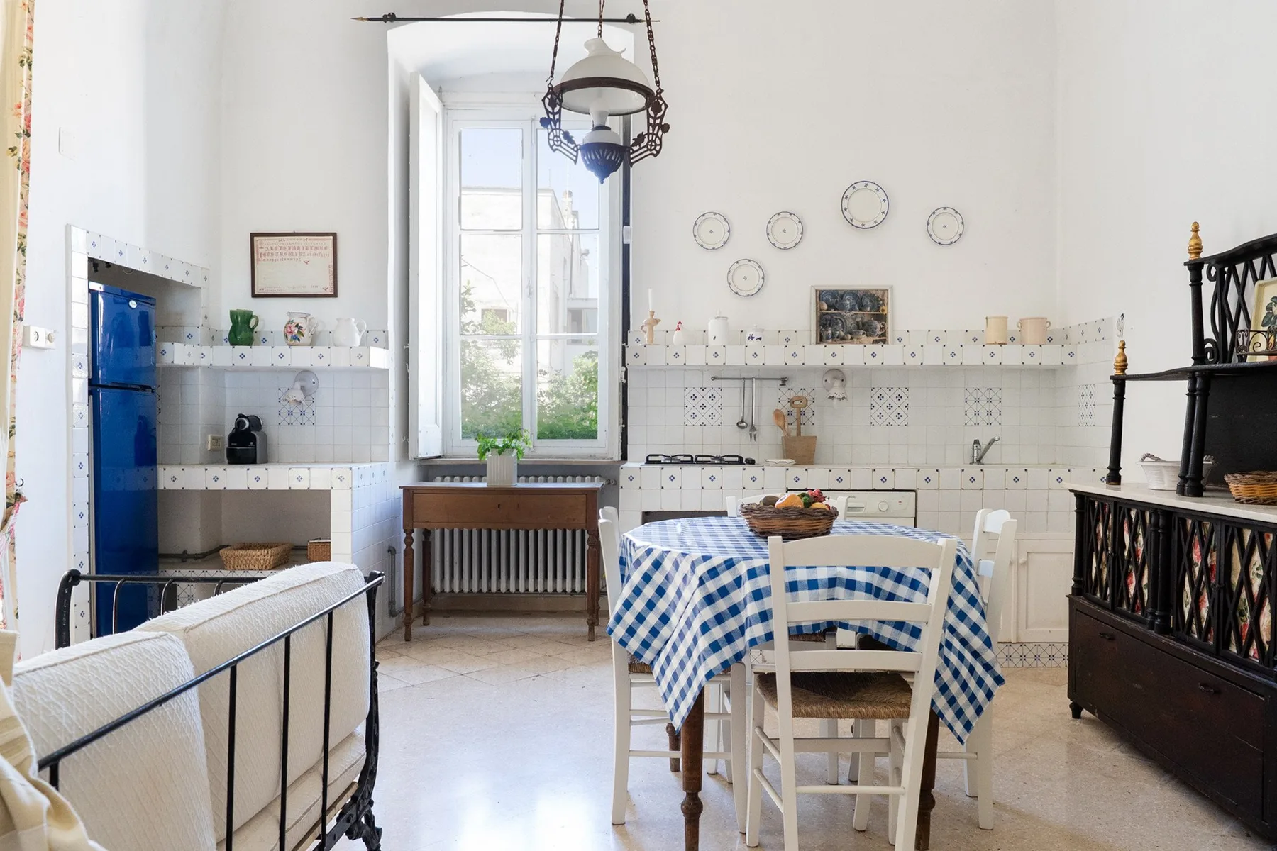 Una cocina y comedor luminosos con un mantel de cuadros azules y blancos.