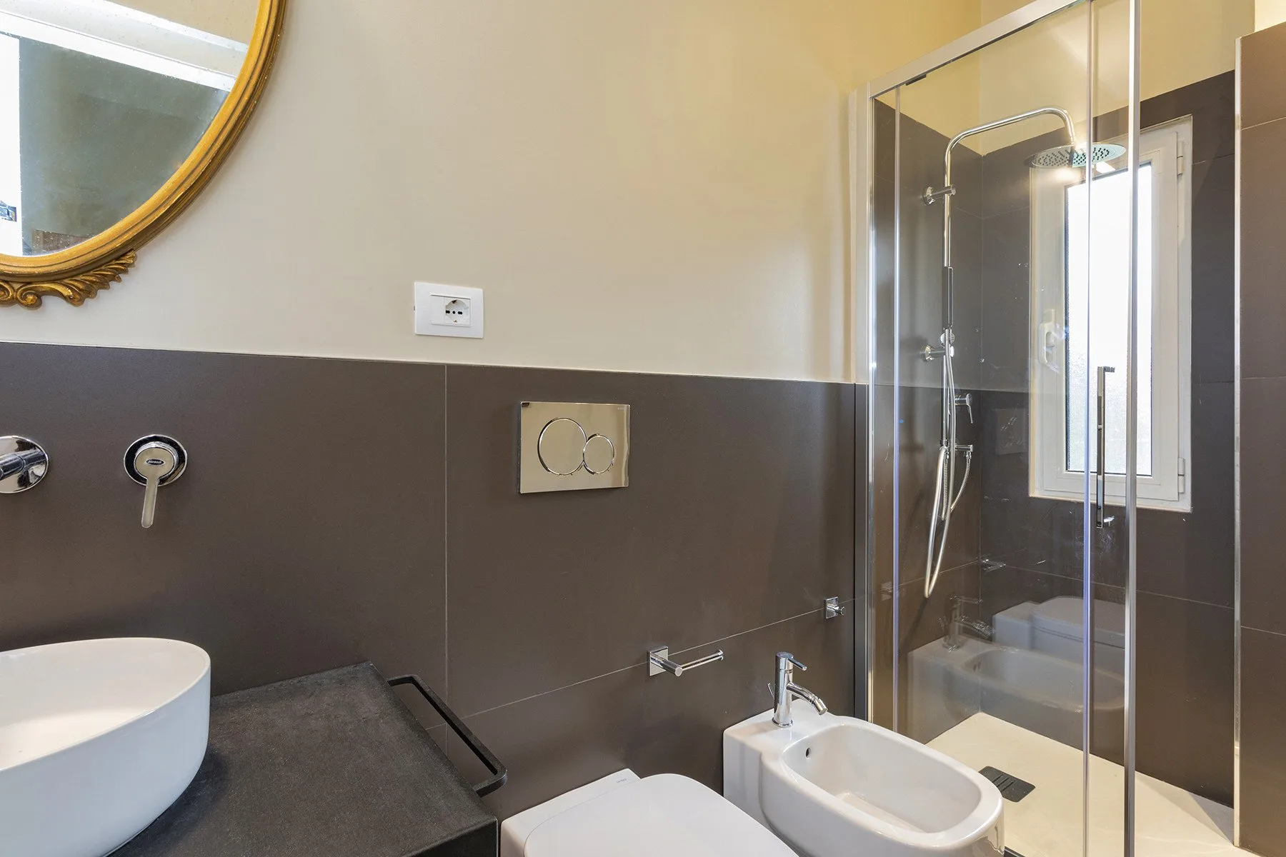 Un baño con una ducha de vidrio y un lavabo blanco.