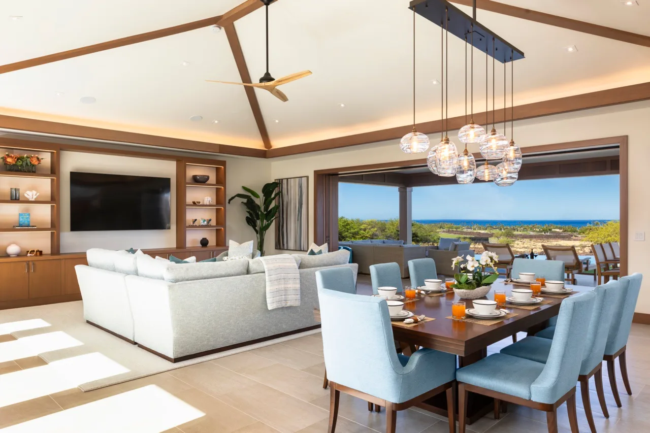 Un salón-comedor de planta abierta con una mesa grande junto a amplios ventanales.
