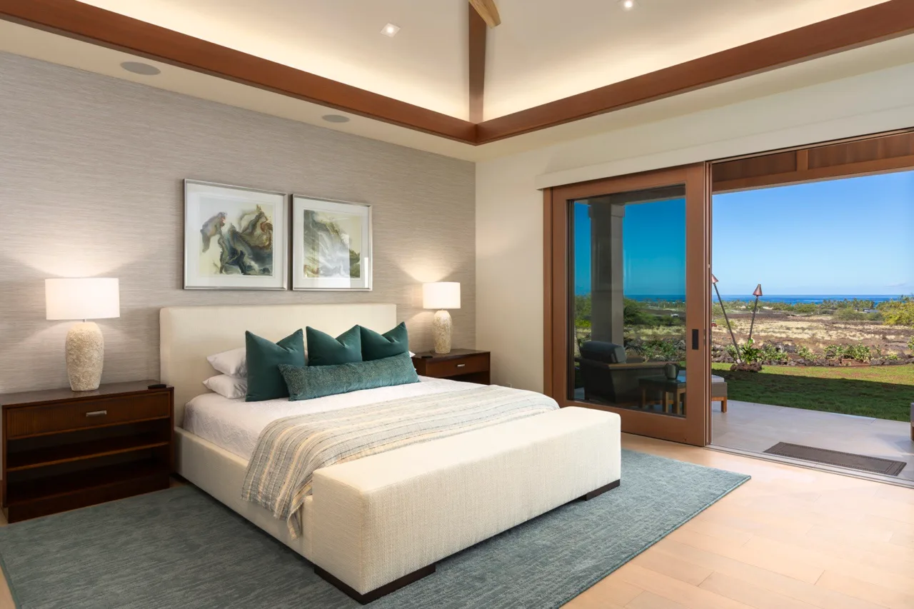 Un dormitorio con una cama y puertas corredizas de vidrio que dan a un patio.