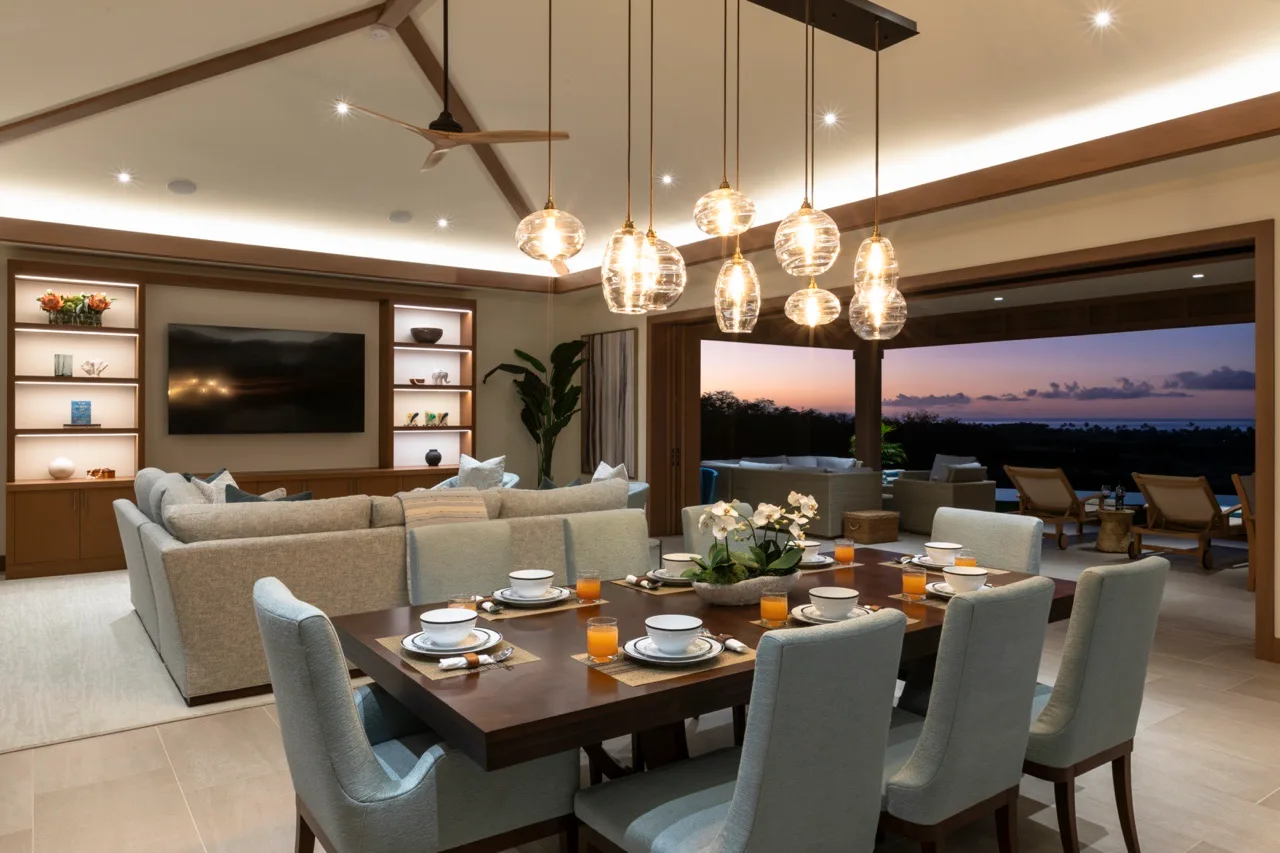 Un comedor con la mesa puesta da a una sala de estar y una terraza abierta.