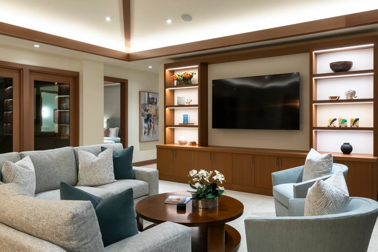 Una sala de estar con asientos alrededor de una mesa de centro y un televisor.