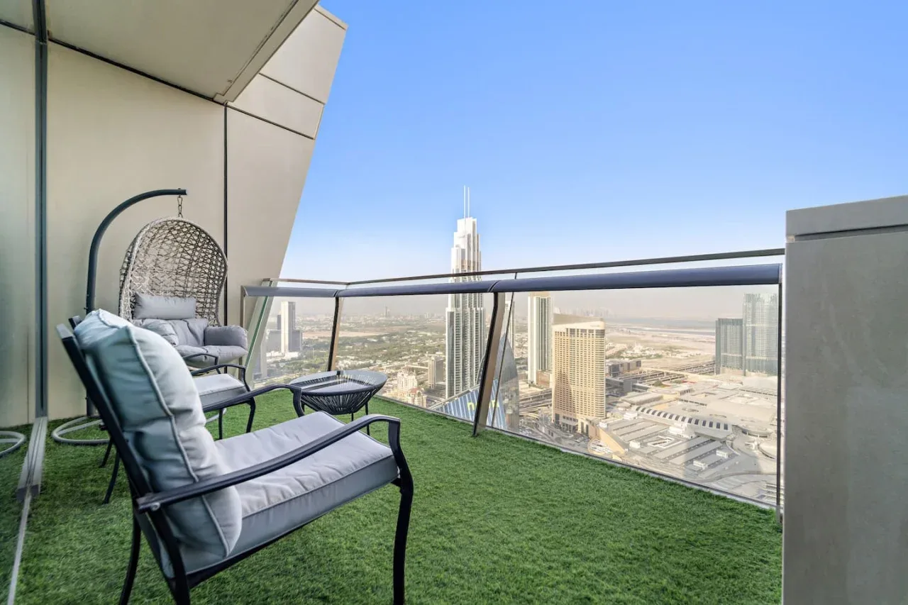 Una zona de estar en un balcón elevado da a un horizonte urbano.