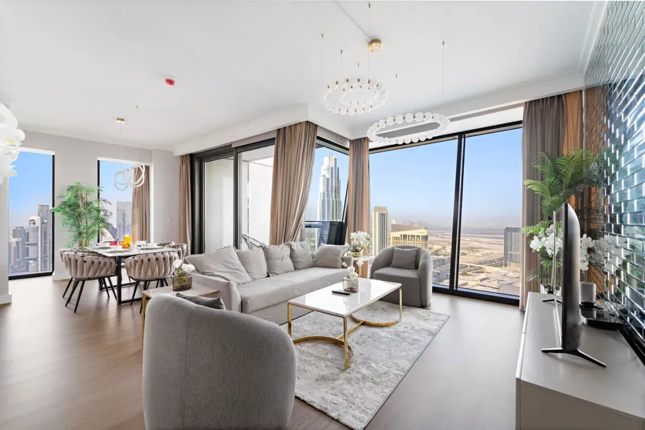 Una sala luminosa con zona de estar, comedor y amplias vistas de la ciudad.