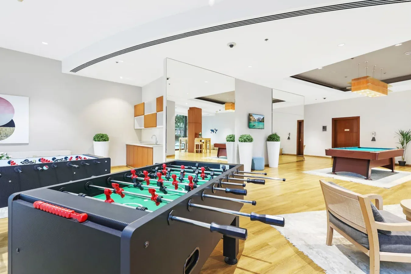 A recreation room features foosball tables and a pool table.