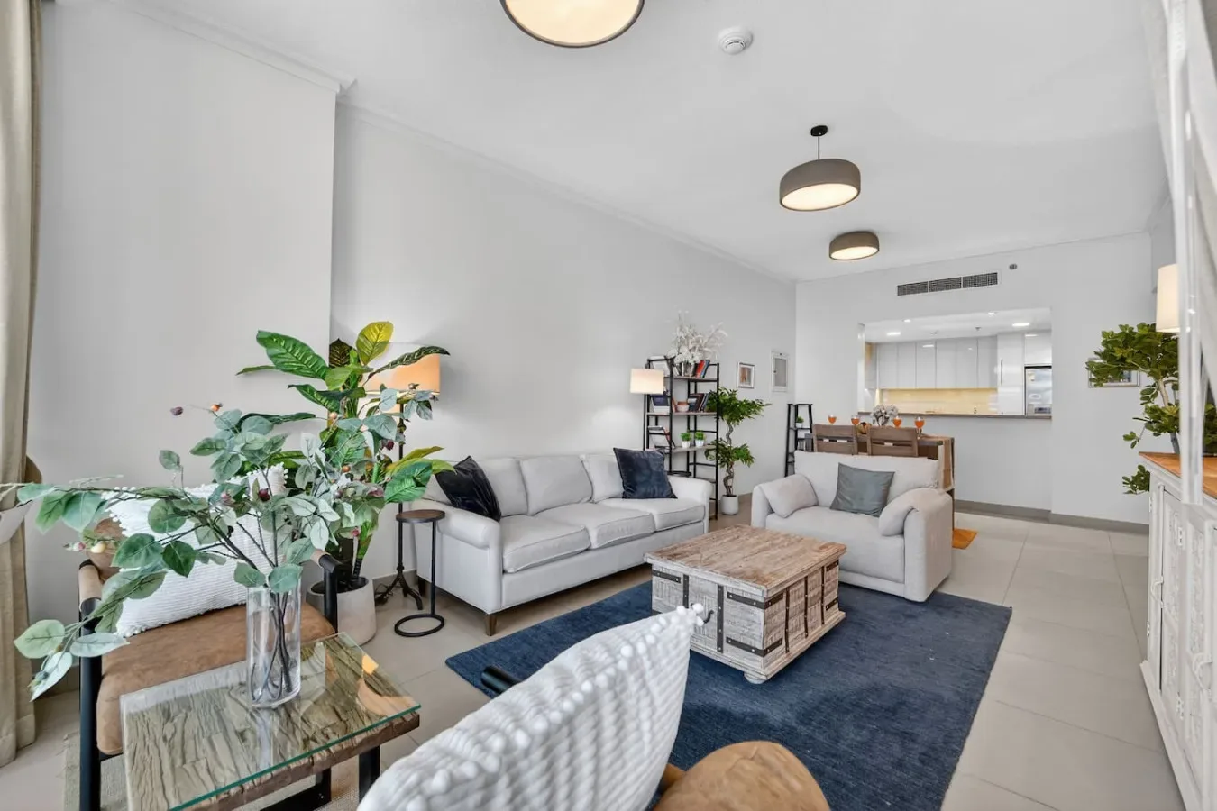 A bright living room with seating, a coffee table, and plants.