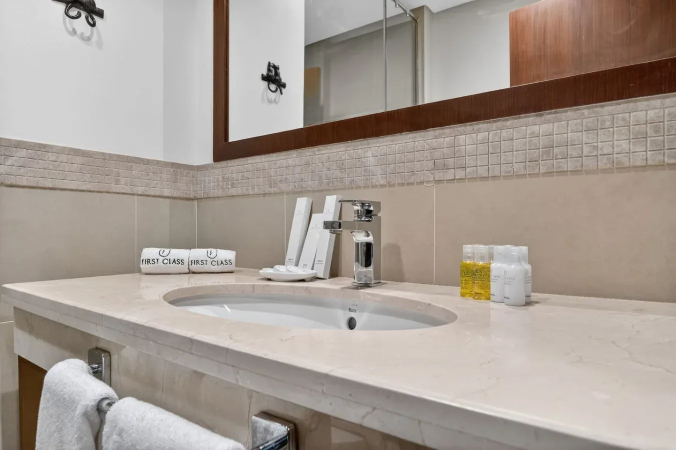 A bathroom vanity with a sink, mirror, and folded towels.