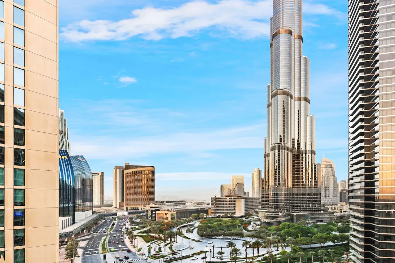 A city skyline with a very tall tower rising above surrounding buildings.