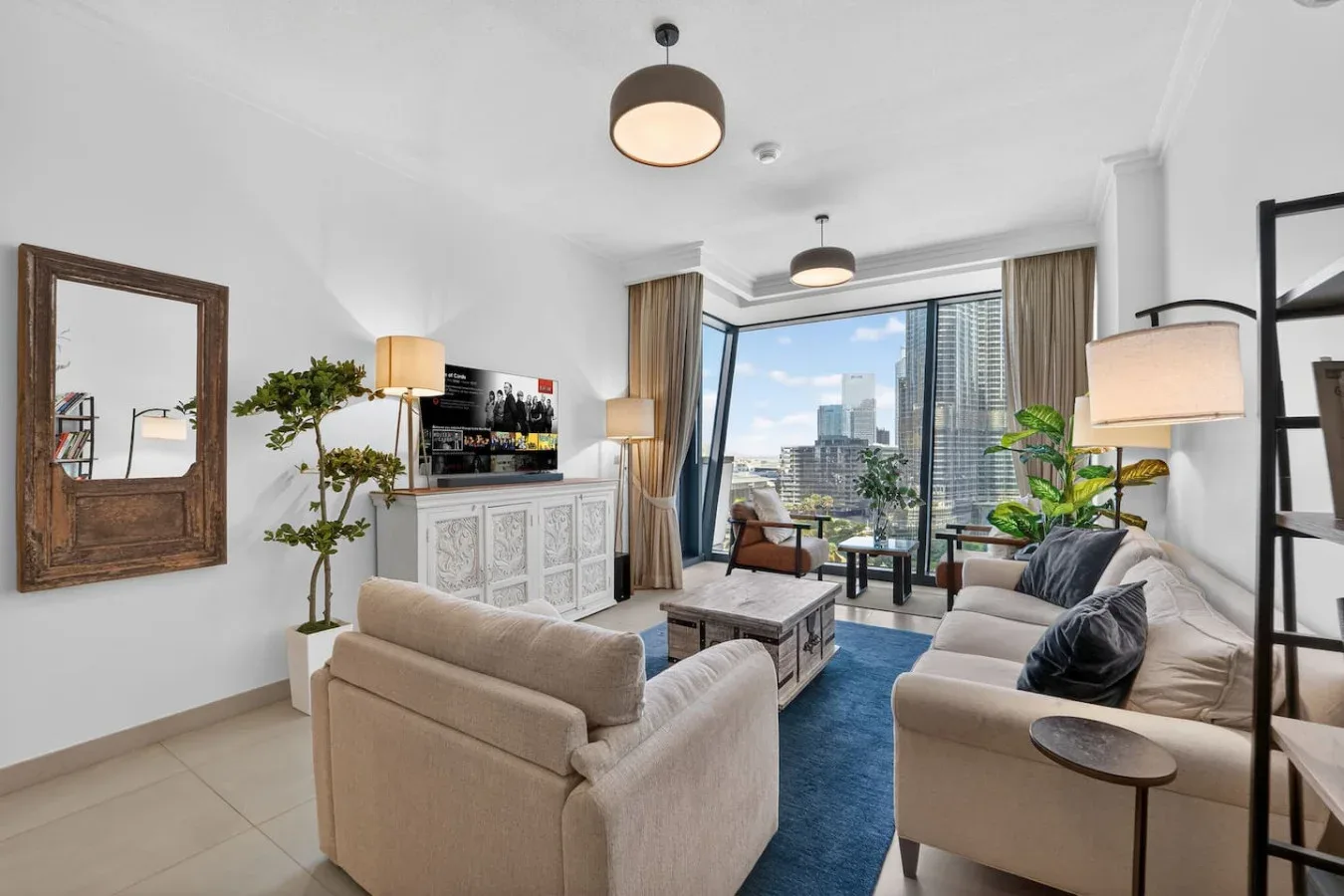 A bright living room with seating, a coffee table, and large windows.