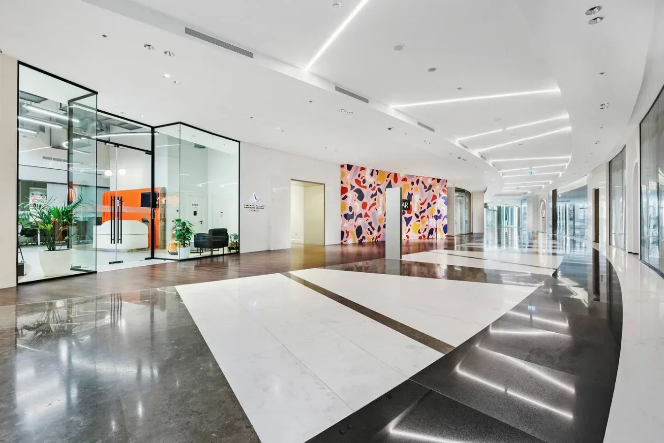A modern lobby with glass office fronts and colorful wall artwork.