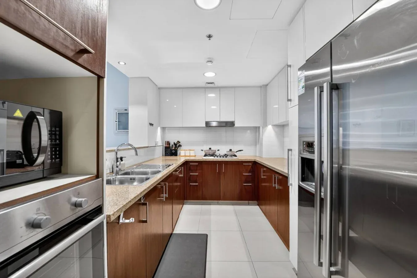 A modern kitchen with wood cabinetry, stainless steel appliances, and a central work area.