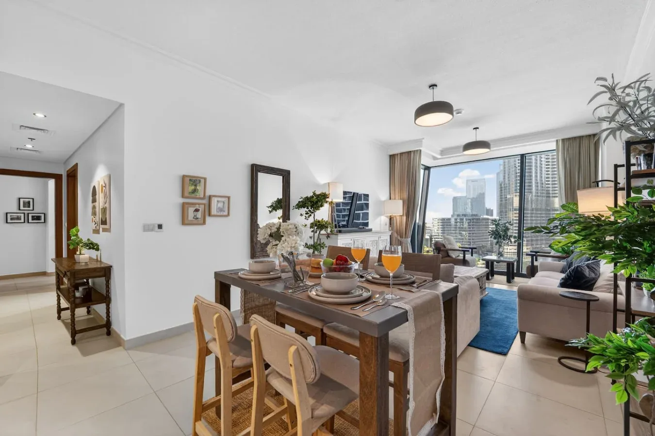 A bright dining and living area features a set table and large windows.