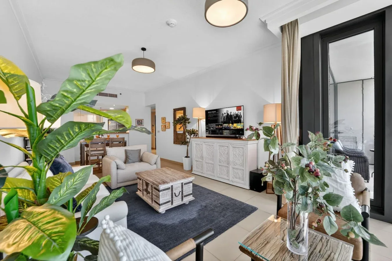 A bright living room with seating, a coffee table, and a television.