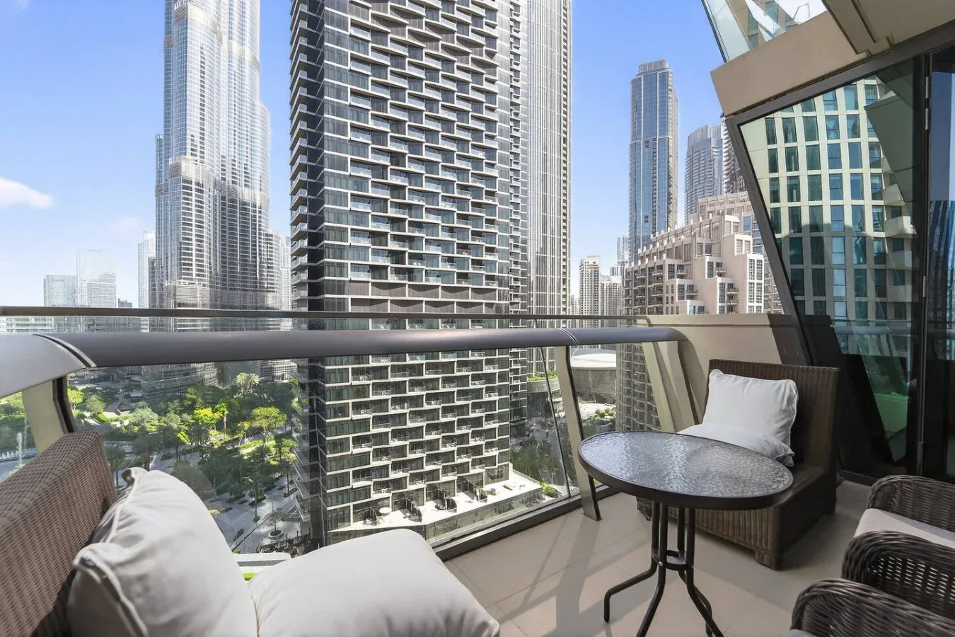 A balcony seating area overlooks a cluster of tall city buildings.