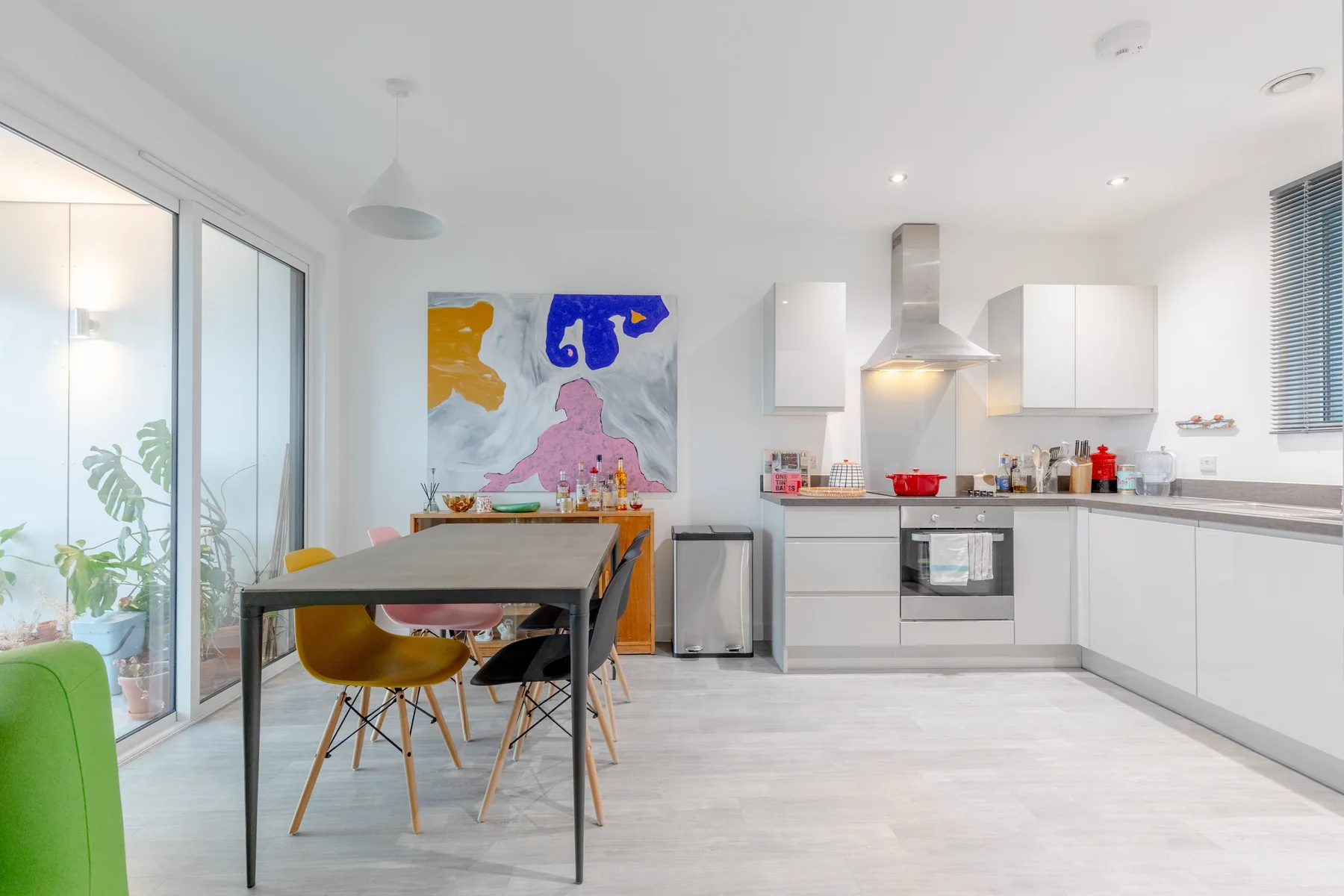 A bright kitchen and dining area with a table beside the cooking counter.