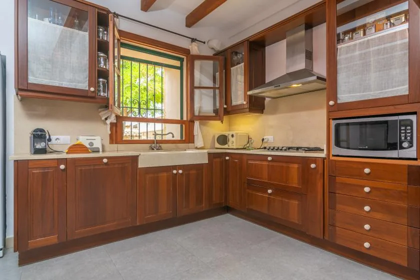 A kitchen with wooden cabinets, a countertop, and a window.