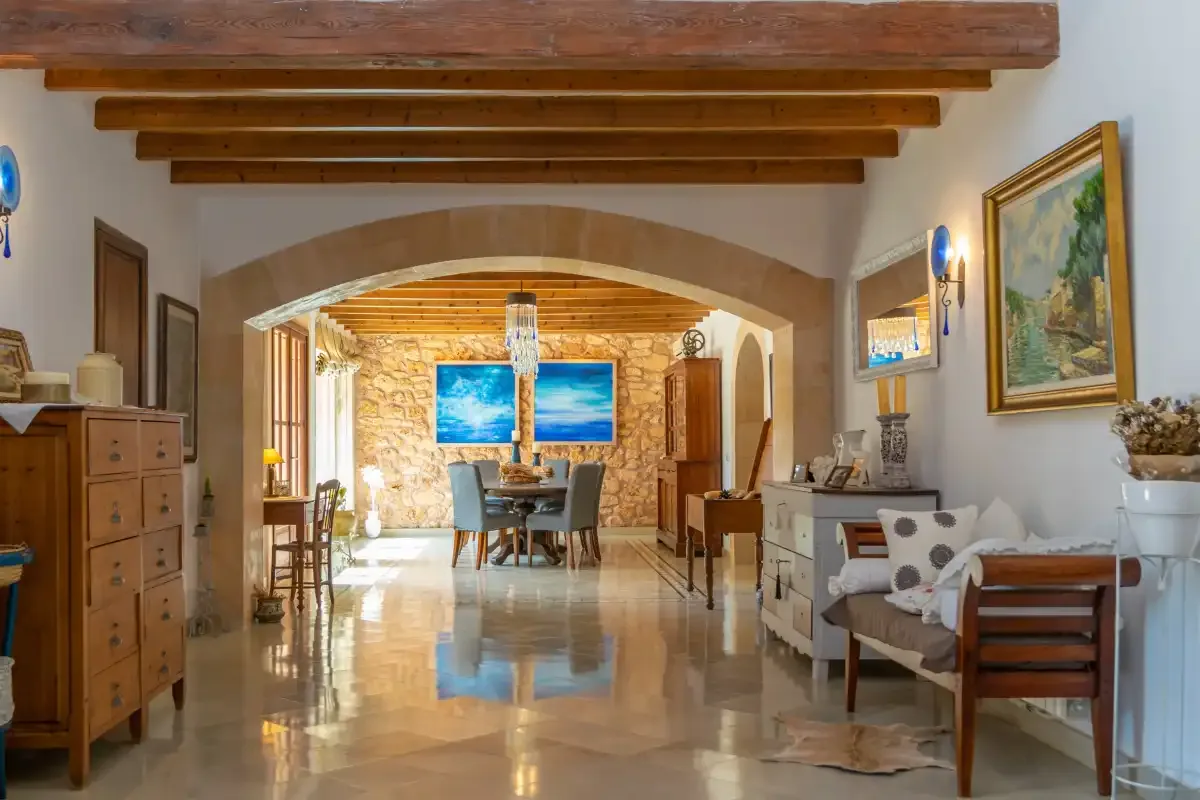 A dining and seating area with exposed wooden ceiling beams.
