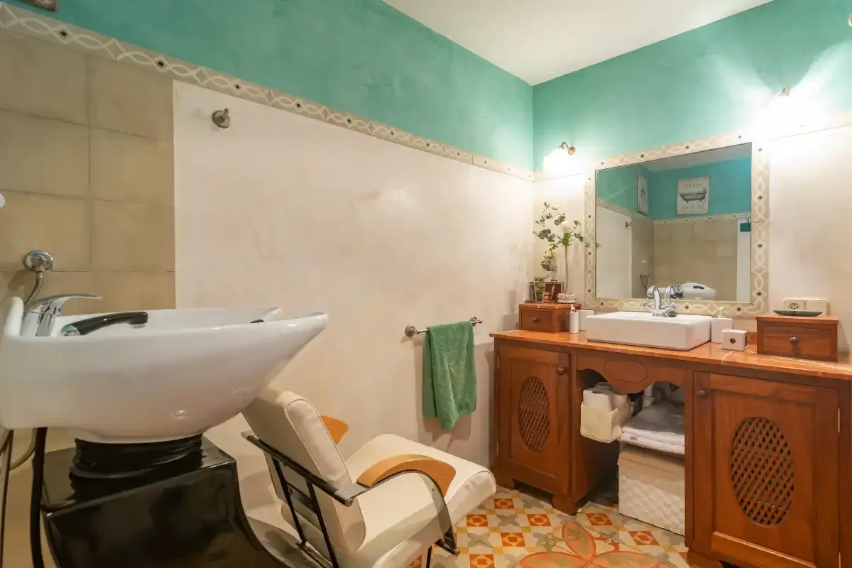 A tiled bathroom with a sink, wooden vanity, and bathtub.