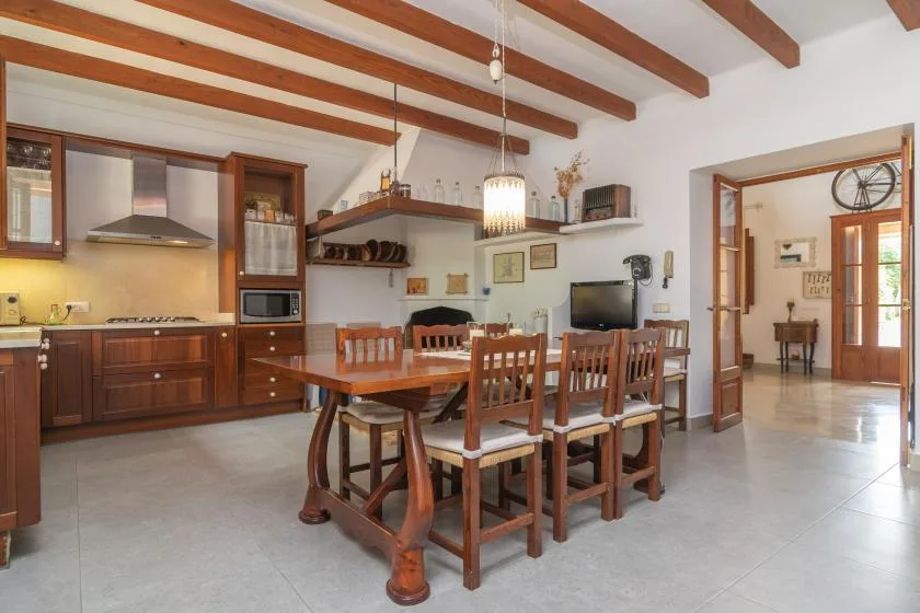 A dining area with a wooden table and chairs beside the kitchen.