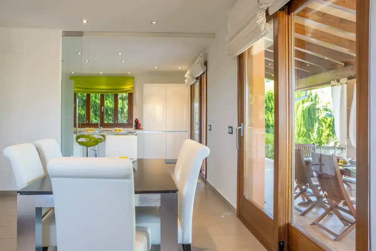 A bright dining area opens onto a covered patio through glass doors.