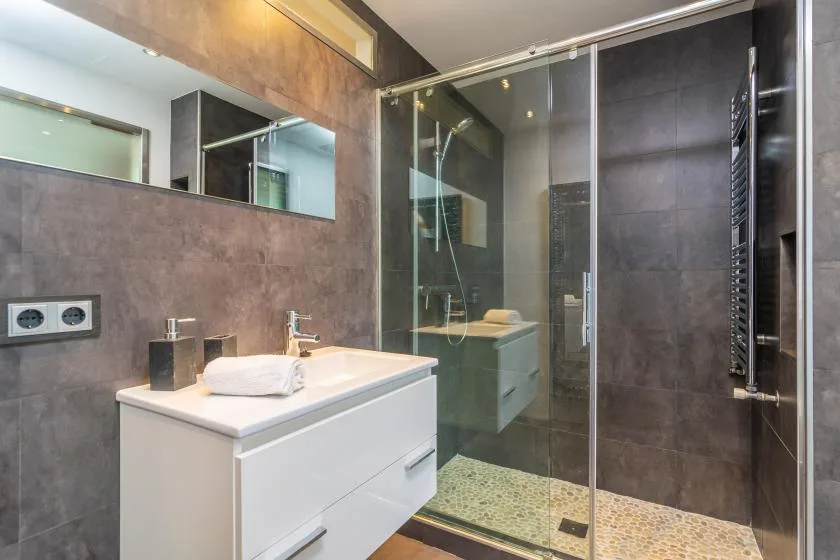 A bathroom with a white vanity and a glass shower.