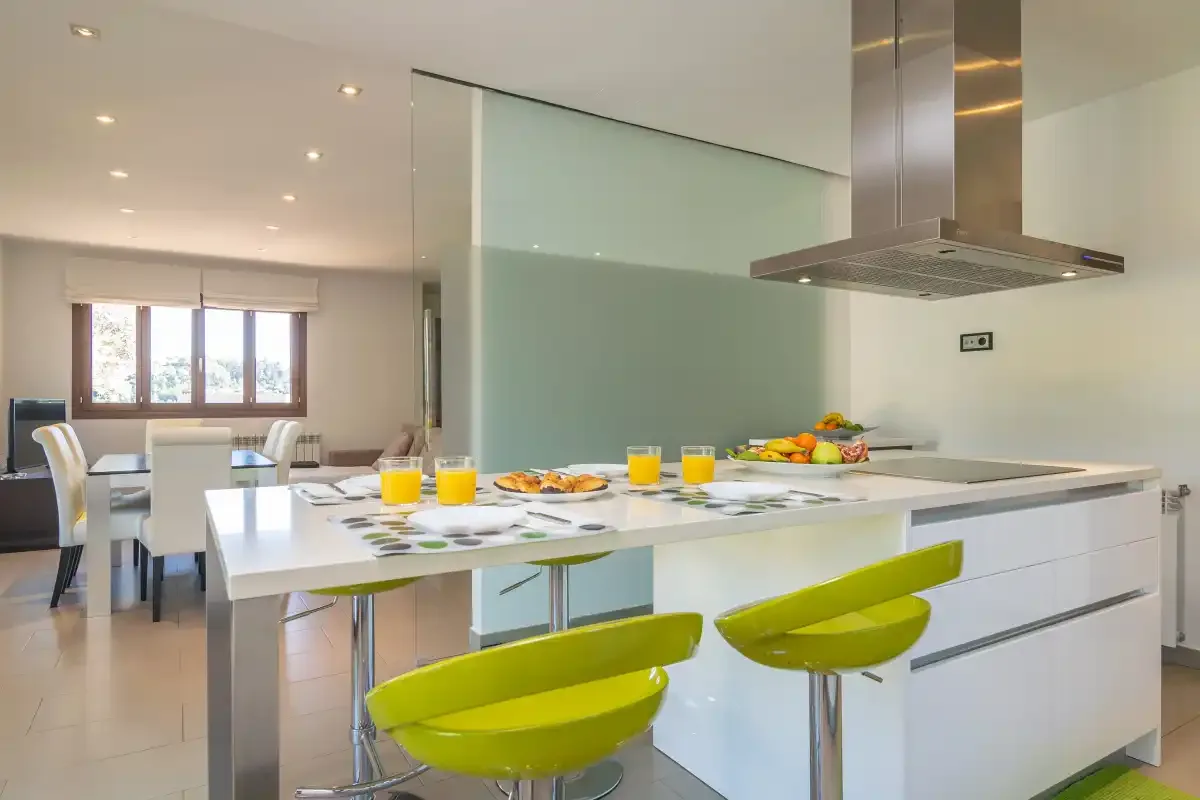 A modern kitchen with a central island and bright green seating.